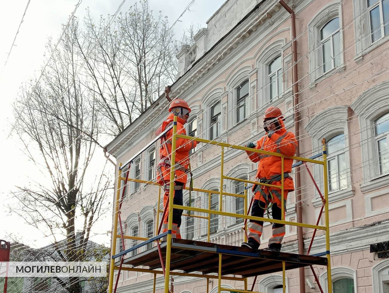 На Ленинской в Могилеве к Новому году готовят красоту — рабочие монтирую подвесные гирлянды